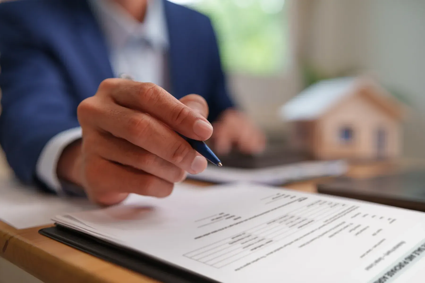 Homeowner reviewing a printed service estimate at a kitchen table before choosing a contractor
